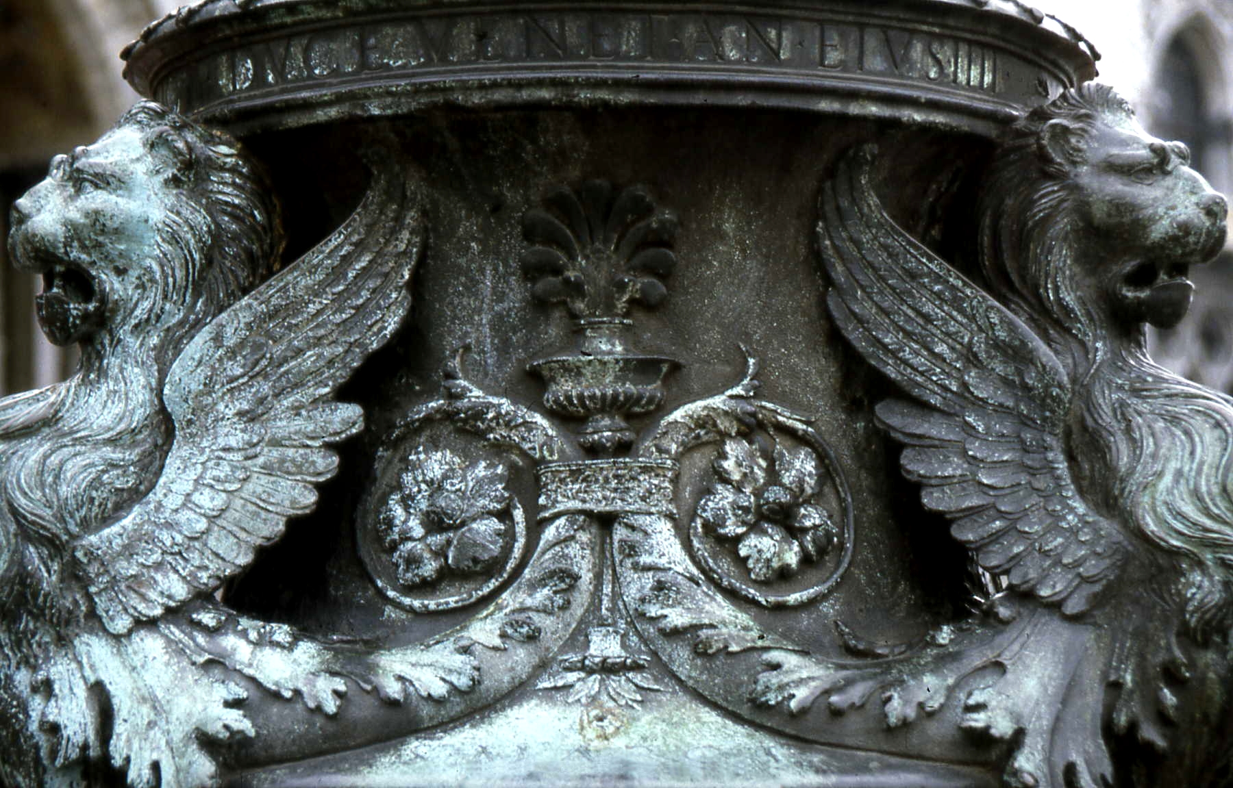 Two lions heads at bottom of a statue